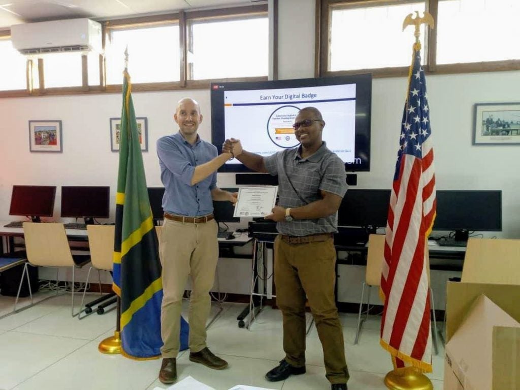 Tanzanian English Language Teachers’ Association (TELTA) President William Mwinuka and English Language Fellow Tyler Theyerl celebrate completing an American English Webinar series with local educators with certificates from RELO Dar es Salaam. 