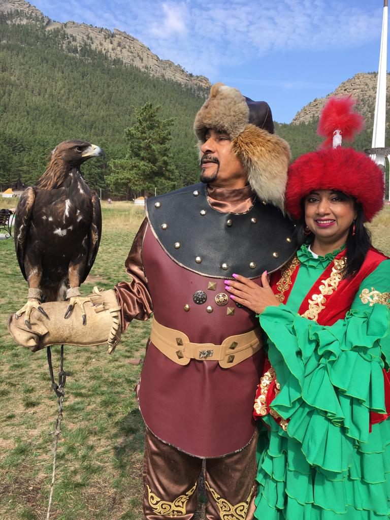 Naila and her husband dress up in traditional Kazakh clothes and pose with a hawk in the Burabai Mountains 