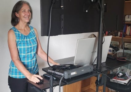 Virtual Educator teaching at a stand-up computer workstation