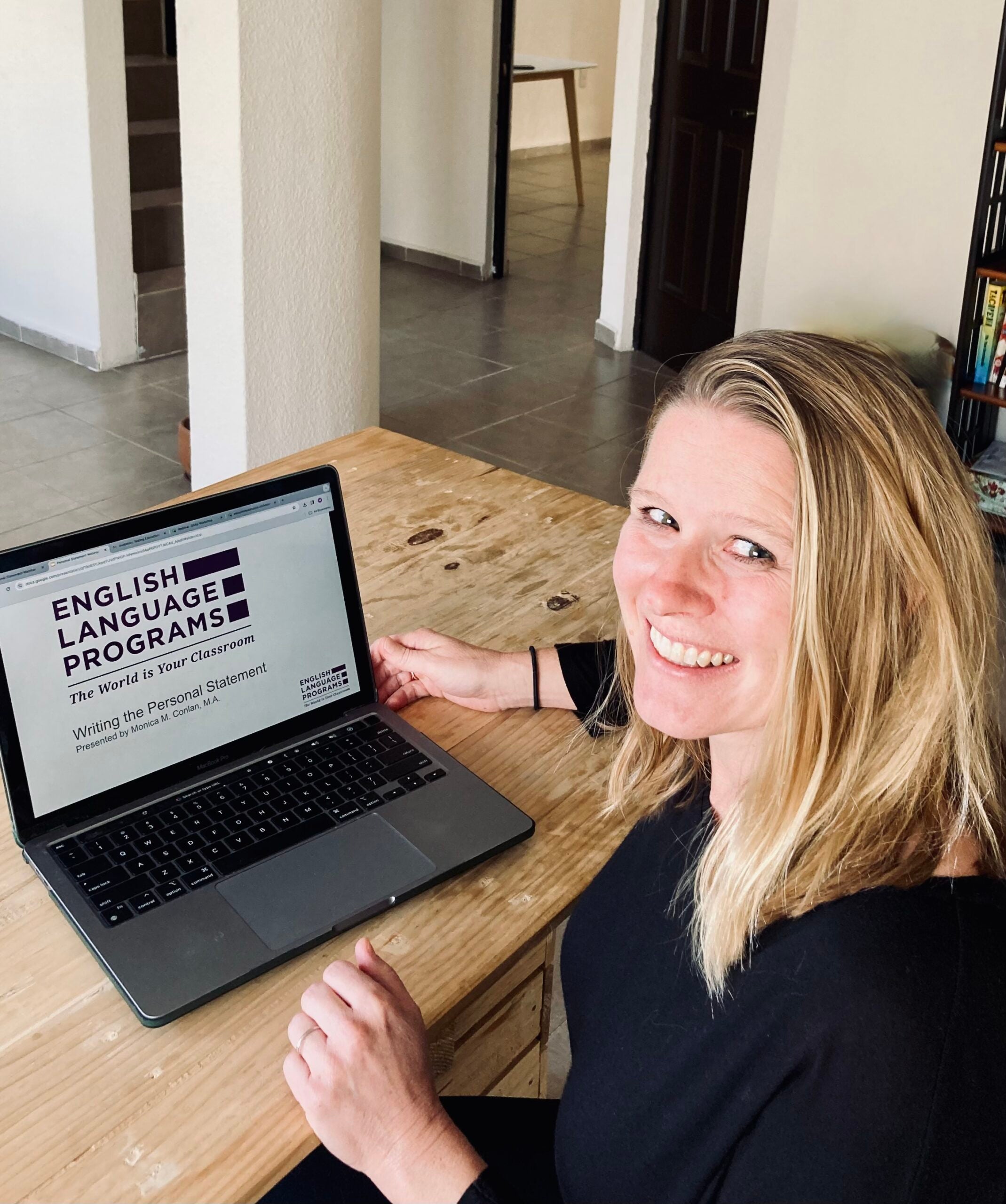 A Virtual Educator sits at her laptop facing the camera.