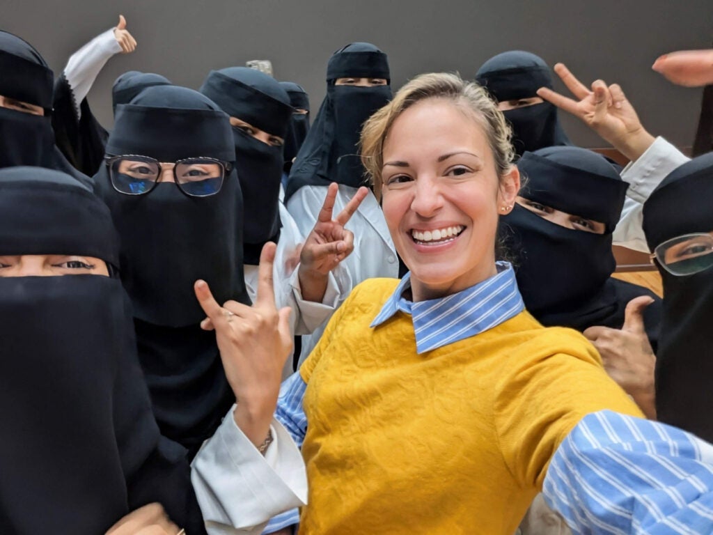 Callahan Neginskiy taking a photo with female medical students (left) and male medical students (right) after the presentation